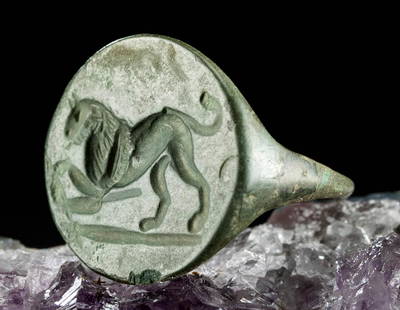 Roman Leaded Bronze Signet Ring w/ Lion: Roman, Imperial Period, ca. 1st to 4th century CE. A handsome leaded bronze signet ring with an incised lion. The shank is comprised of a thin band and the face of the ring is incised with a lion in