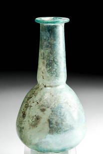 Roman Glass Flask w/ Lovely Iridescence: Roman, Imperial Period, ca. 2nd to 3rd century CE. A beautiful, mold-formed flask comprised of semi-translucent, pale blue-green glass with a flat base, a globular body which tapers to an indented