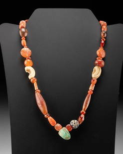 Roman Carnelian, Shell, Coral, Glass, & Stone Necklace: Roman, Imperial Period, ca. 2nd to 4th century CE. A beautiful necklace comprised of dozens of ancient beads made from shell, coral, glass, carnelian, and greenstone. The beads are tubular, barrel,