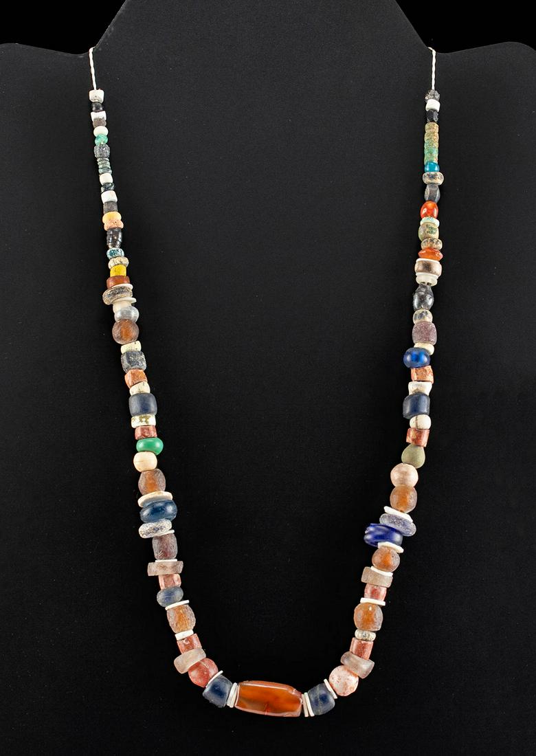 Phoenician Glass, Carnelian, Shell, & Faience Necklace: Classical World, Eastern Mediterranean, Phoenician, ca. 6th to 1st century BCE. A fabulous strand of ancient glass, shell, carnelian, and faience beads strung on modern thread as a necklace. There are