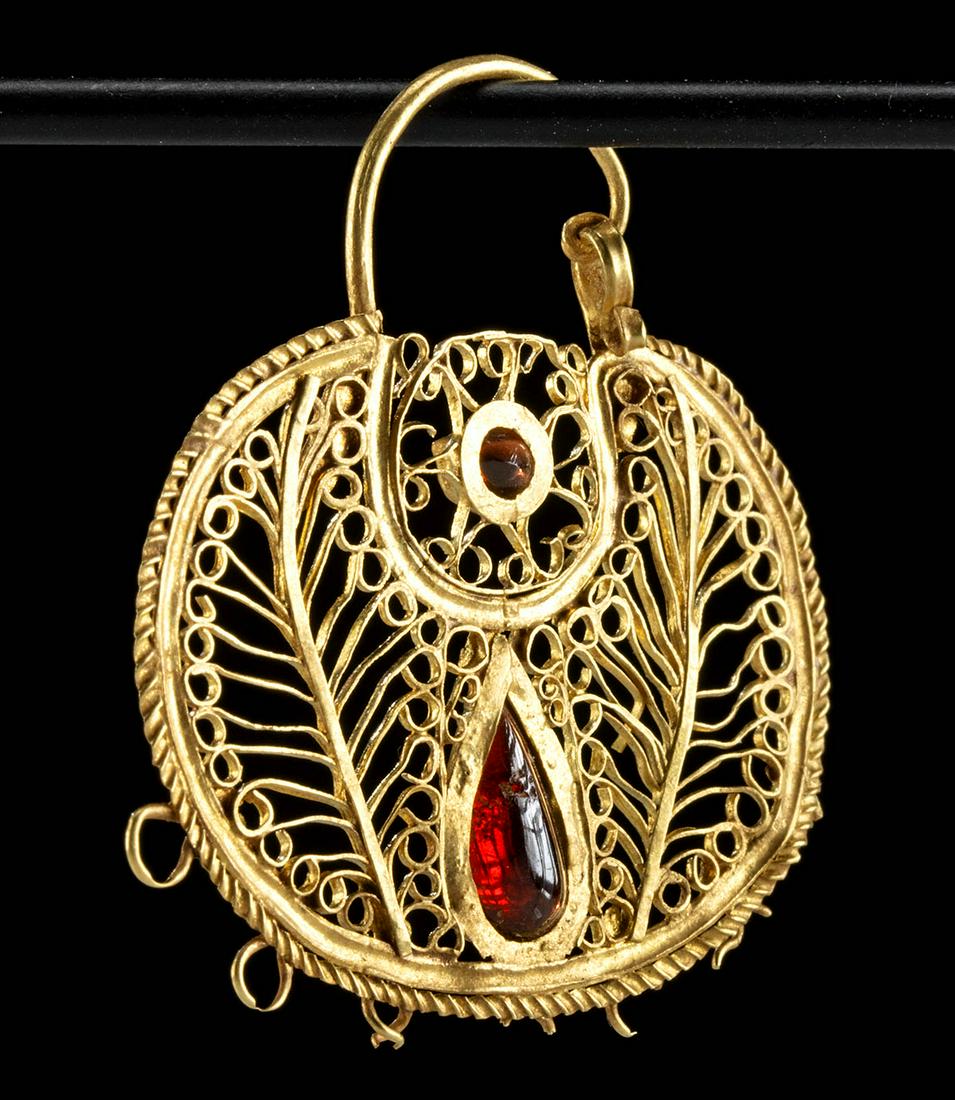 10th C. Byzantine Gold Filigree Earring w/ Garnets: Near East / Holy Land, Byzantine Empire, ca. 10th to 12th century CE. Absolutely breathtaking, this 76.29% gold (equivalent to 18K+) and garnet earring boasts an exquisite design and is dripping with 