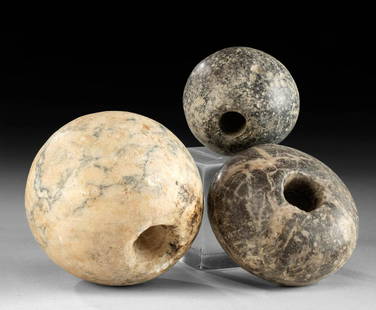 Egyptian Pre-Dynastic Stone Mace Heads, ex-Sotheby's: Egypt, pre-Dynastic / Naqada II period, ca. 3500 to 3000 BCE. Three hand-carved stone mace heads of rounded forms and with cylindrical hafting slots drilled vertically through the bodies of two and