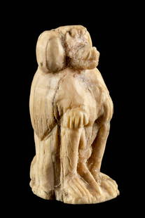 Miniature Egyptian Bone Baboon Amulet: Egypt, Late Dynastic to Ptolemaic Period, ca. 664 to 30 BCE. A miniature votive amulet carved from cow or ox bone depicting a seated baboon with hands placed neatly upon its bent knees. The baboon is