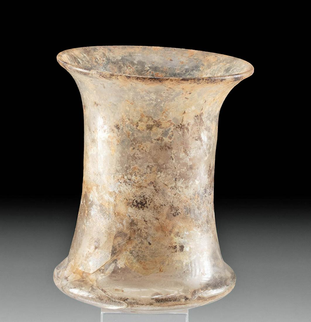 Roman Glass Beaker Cup, ex-Bonhams: Roman, Imperial Period, ca. 1st to 3rd century CE. An elegant glass beaker with a semi-translucent body and a carinated rim above the base. The body rises upward then flares out at the rim. A heavy la