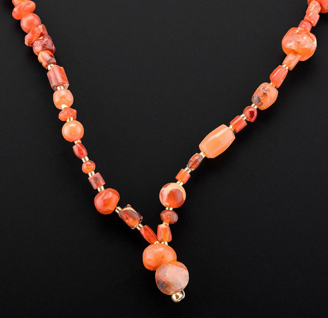 Wearable Roman Carnelian Bead Necklace: Roman, Imperial Period, ca. 1st to 3rd century CE. A fabulous and wearable necklace composed of dozens of ancient carnelian stone beads in hues of vermilion with creamy inclusions. The beads are carve
