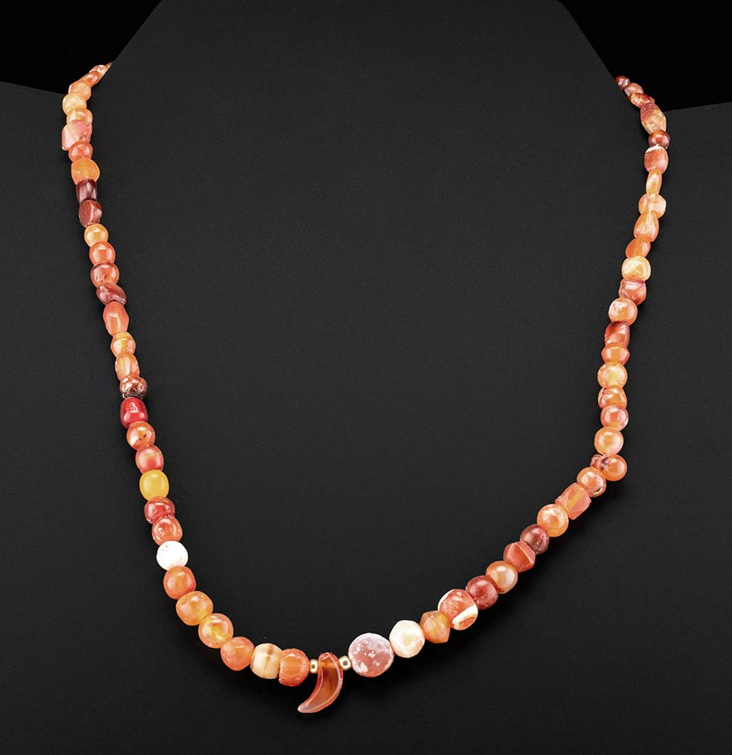 Gorgeous Roman Carnelian Bead Necklace: Roman, Imperial Period, ca. 1st to 3rd century CE. A gorgeous necklace strung with dozens of petite carnelian beads of warm vermilion hues. A couple of beads exhibit hues of translucent white, orange,