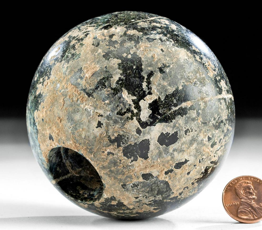 Ancient Bactrian Stone Spherical Mace Head: Ancient Central Asia, Bactrian culture, ca. 3rd to 2nd millennium BCE. A beautiful spherical mace head, carved by hand and polished from a mottled black stone with light-green and grey inclusions, wit