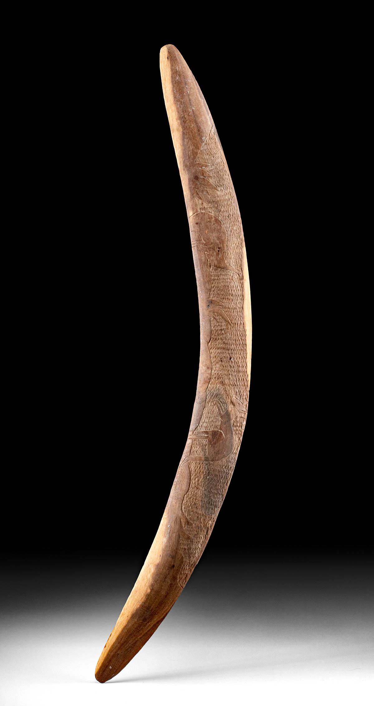 Antique Australian Aboriginal Wood Boomerang w/ Carving: Oceania, Australia, Aboriginal peoples, ca. early 20th century CE. A hand-carved wooden boomerang with a slightly curved profile and zoomorphic motifs. The front side is etched with dotted markings th