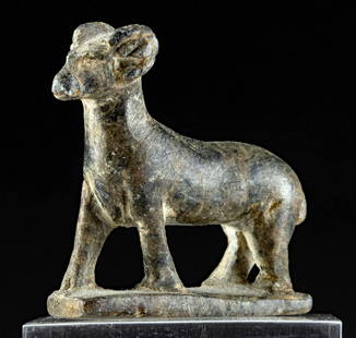 Egyptian Late Period Steatite Striding Ram Amulet: Egypt, Late Dynastic to Ptolemaic Period, ca. 664 to 30 BCE. A fine amulet carved from mottled brown and dark gray steatite showcasing a ram striding forward atop an integral rectangular plinth. The