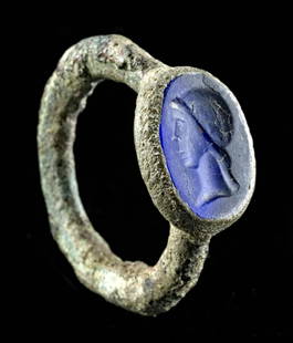 Roman Lead Copper Alloy Ring w/ Blue Glass Intaglio: Roman, Imperial period, ca. 1st to 3rd century CE. An excellent lead/copper alloy ring with a thick band and ovoid glass intaglio inlay. Adorned in a rich hue of ultramarine, the intaglio displays a