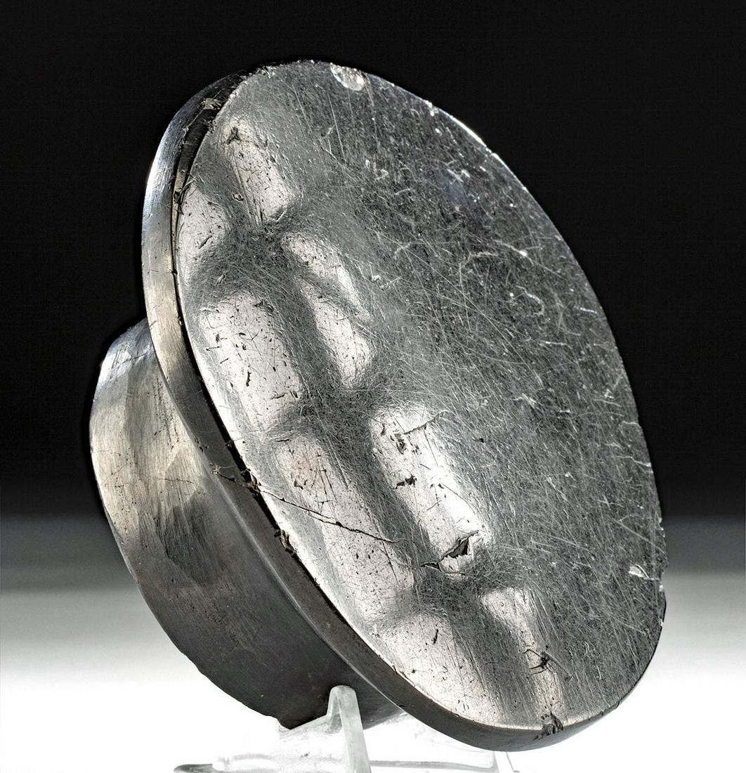 Reflective Chavin Anthracite Mirror: **First Time At Auction** Pre-Columbian, Northern Peru, Chavin culture, ca. 900 to 500 BCE. A hand-carved mirror, formed with a large piece of black anthracite. The mirror is shaped with a concave rin
