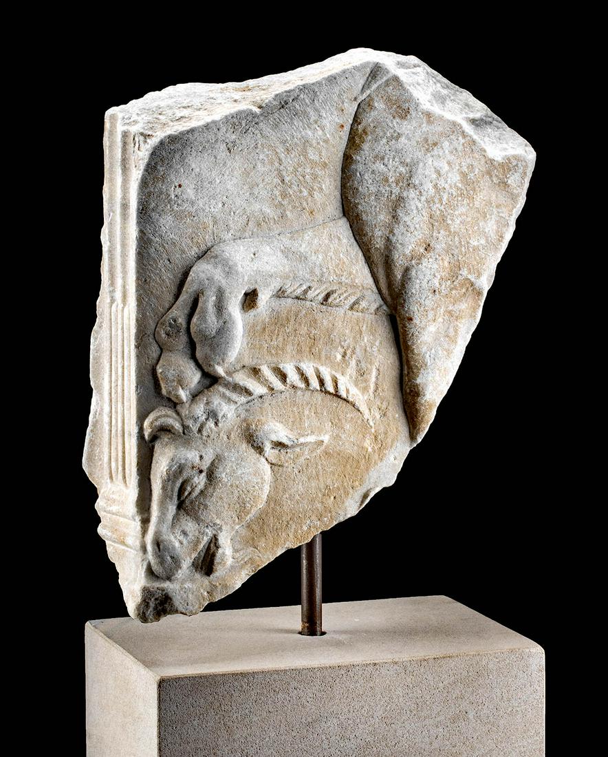 Roman Marble Relief with Lion's Paw and Ram's Head: Roman, Imperial, ca. 1st to 3rd century CE. A fabulous fragment of a marble relief featuring the head of a ram and the paw of a lion. Facing left, the ram's head is shown in profile in the bottom left