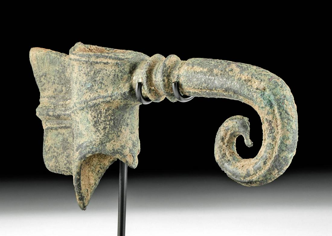 Rare Luristan Bronze Mace Head Fanciful Form: Ancient Near East, modern day Iran, Luristan, ca. 1100 BCE. A lovely cast bronze mace head with a fanciful form, featuring a cylindrical socket, a wing-like butt, and a curling, elephant-snout-like fi