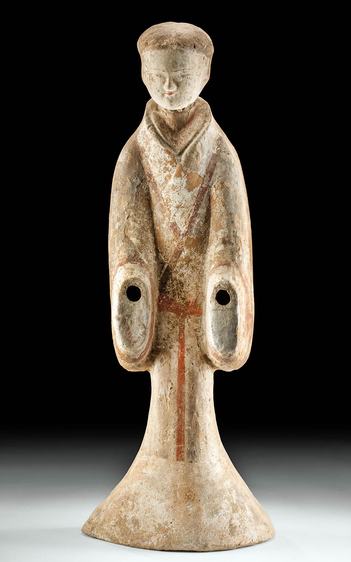 Beautiful Chinese Han Terracotta Female Tomb Attendant: East Asia, China, Han Dynasty, ca. 206 BCE to 220 CE. A very large female tomb attendant, elegant and evocative. She stands facing forward, with her arms at her sides. The openings in the sleeves of h