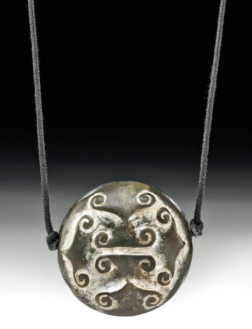 Chinese Ming Dynasty Stone Pendant: East Asia, China, Ming Dynasty, ca. 1368 to 1644 CE. A finely carved stone pendant of a discoid form with a biconically drilled suspension hole through the midsection. Both faces are carved with six p