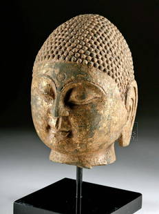 Chinese Qi Dynasty Gilded Stone Buddha Head: East Asia, China, Northern Qi Dynasty, ca. 550 to 577 CE. An incredibly preserved limestone carving of the head of Buddha, with nice remaining dark pigment, especially on the hair, and gilding on the