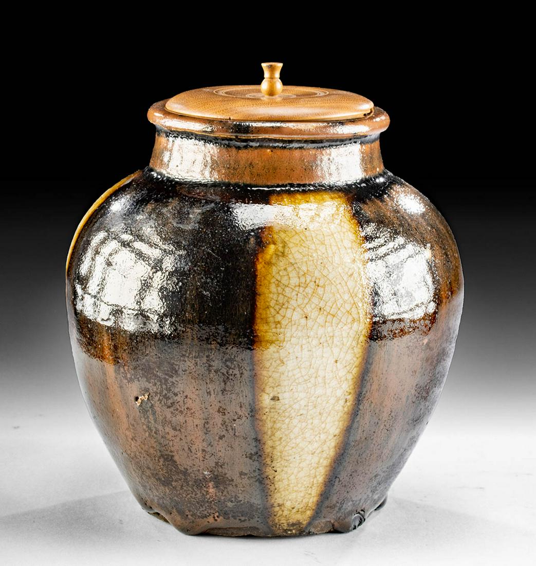 17th C. Japanese Edo Glazed Pottery Jar + Wood Lid: East Asia, Japan, Edo period, ca. 17th century CE. An attractive pottery jar presenting a circular, concave base, an apple-form body, a cylindrical neck, and an annular flared rim. Boasting a lustrous