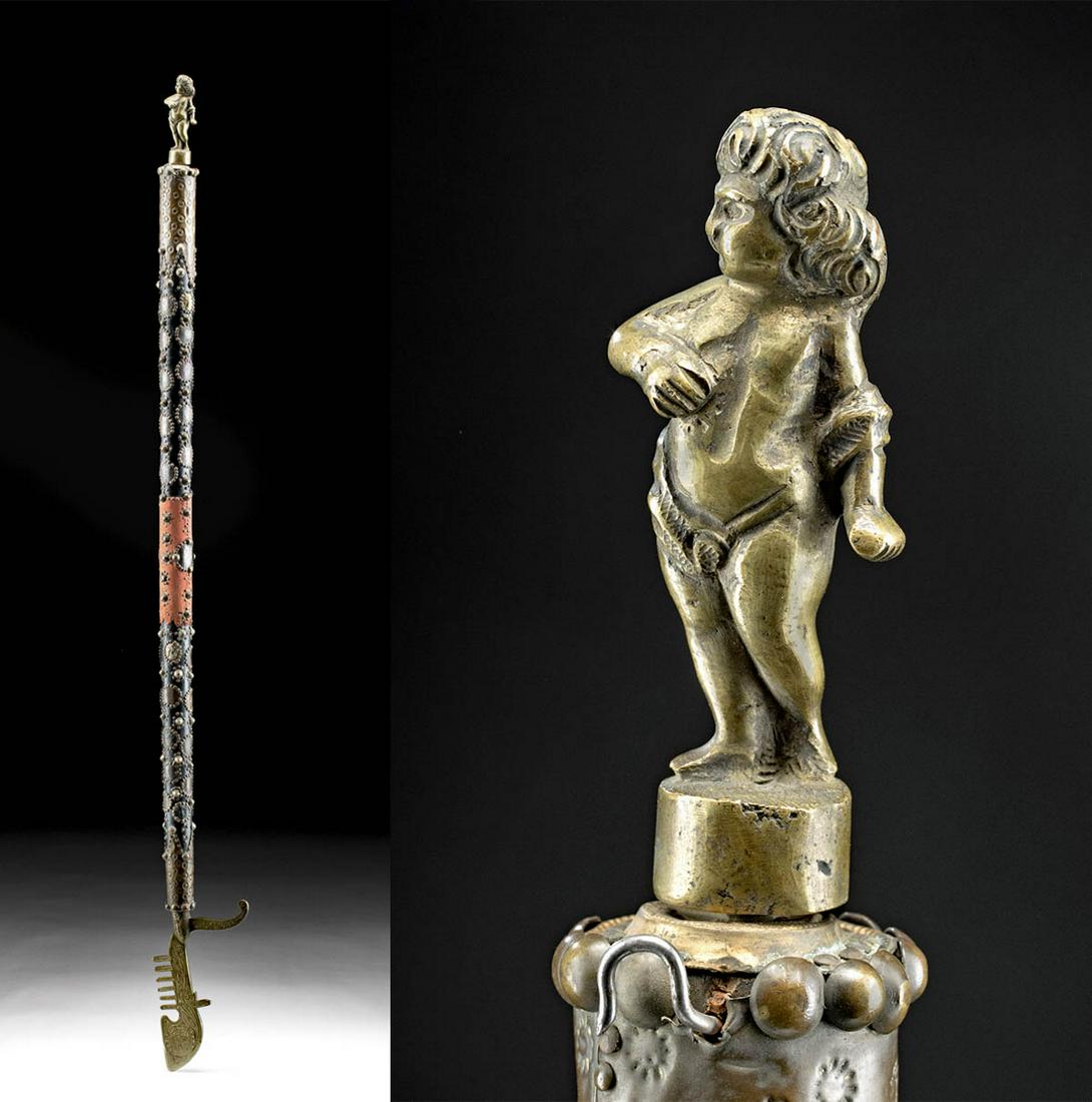 19th C. Indian Wood & Metal Staff w/ Coins & Cherub: South Asia, India, Colonial Period, ca. 19th to early 20th century CE. An interesting staff with a long wooden handle that is covered with an array of brass, copper, tin, and nickel ornaments. The top
