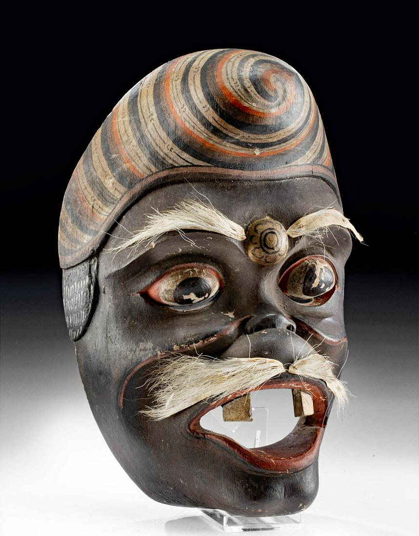Early 20th C. Balinese Wood Festival Mask w/ Goat Hair: Southeast Asia, Indonesia, Bali, ca. early 20th century CE. An expressive wooden festival mask with painted motifs and goat hair facial details. The visage represents an older man with a surprised loo