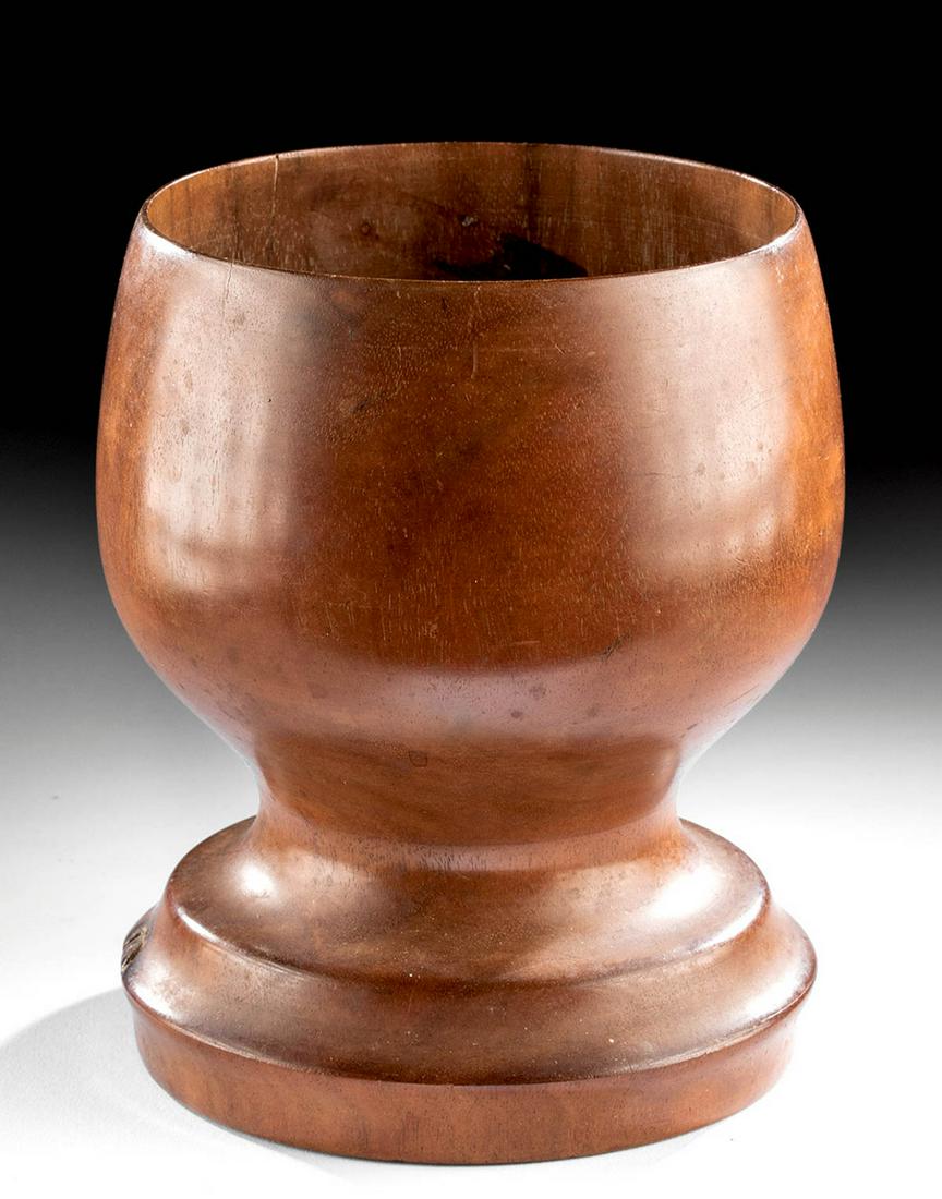 19th C. Hawaiian Milo Wood Vessel Umeke: Polynesia, Hawaii, ca. 19th century CE. A wooden cup made from the inherently beautiful Hawaiian hardwood called milo. This example has a short, tapered leg and a round foot, which is a rare variation