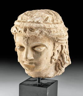 Gandharan Stucco Head of Buddha / Prince Gautama: Central Asia, Pakistan and Afghanistan, Gandharan Empire, ca. 200 BCE to 300 CE. An elegant stucco bust of Buddha as a young man, perhaps as Prince Gautama, modeled in the traditional Greco-Buddhist