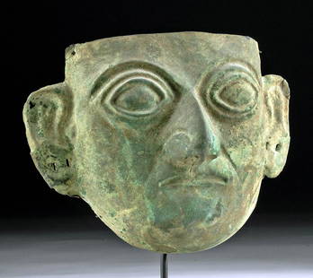 Life-Size Moche Copper Funerary Mask, ex-Sotheby's: Pre-Columbian, North Coast Peru, Pampa Grande, ca. 550 to 700 CE. An impressively preserved, enigmatic, hammered-copper funerary mask representing the stylized head of an elite woman or man, with