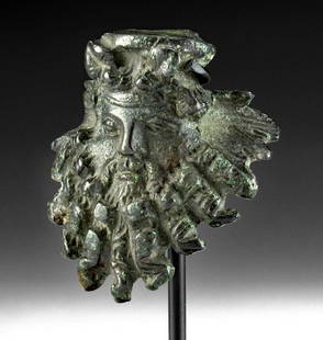 Published Hellenistic Bronze Mask Applique of Dionysus: Greece, Hellenistic Period, ca. 3rd to 1st century BCE. An exquisite example of a cast-bronze applique depicting the elderly face of Dionysus (also Dionysos, Roman Bacchus). Exhibited on the face of