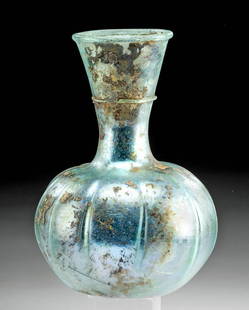 Roman Glass Flask - Incredible Iridescence!: Roman, Imperial period, ca. 3rd to 4th century CE. A gorgeous mold-formed glass flask boasting a translucent hue of pale turquoise. The ancient vessel exhibits an apple-form body supported by a