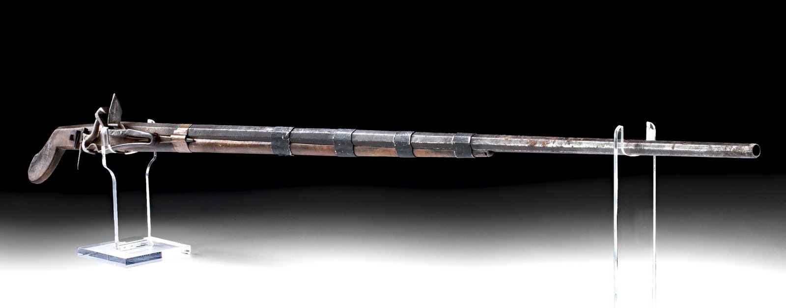 19th C. Tibetan Steel & Iron Rifle w/ Pistol Grip: Central Asia, Tibet, ca. 19th century CE. An interesting iron and wooden flintlock rifle with an octagonal barrel and pistol shaped stock. The flintlock mechanism is on the right side of the stock wit