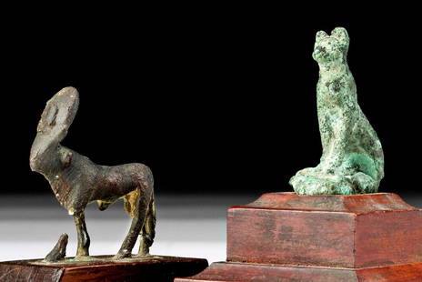 Egyptian Bronze Cat + Apis Bull, ex Parke-Bernet: Egypt, Late Dynastic to Ptolemaic Period, ca. 664 to 30 BCE. A striking pair of cast-bronze figures from ancient Egypt; a cat and an Apis bull. Seated upon its plump haunches with its sinuous tail wra