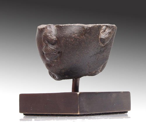 Egyptian Basalt Head of a Youth: Ca. 26th Dynasty, 664 - 525 B.C. The fragment with detailed ears, lips and nose, remaining traces of modeling to the eyes, wearing a side-lock. 1 3/8"H (3.6cm) x 2-1/4"W (5.8cm). PROVENANCE: Ex- T.Z C
