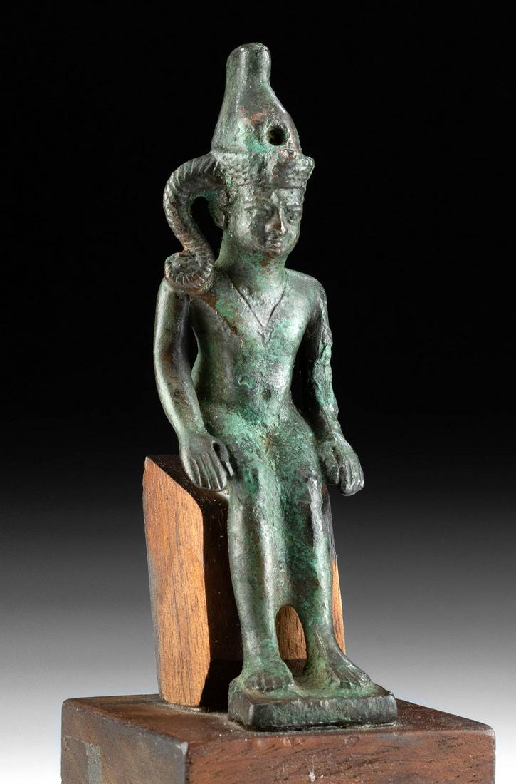 Egyptian Leaded Bronze Seated Horus / Harpokrates: Ancient Egypt, Late Dynastic Period, 26th to 31st Dynasty, ca. 664 to 332 BCE. A charming leaded-bronze cast statue depicting the youthful god Harpokrates (from the Egyptian "Her-pa-khered," literally