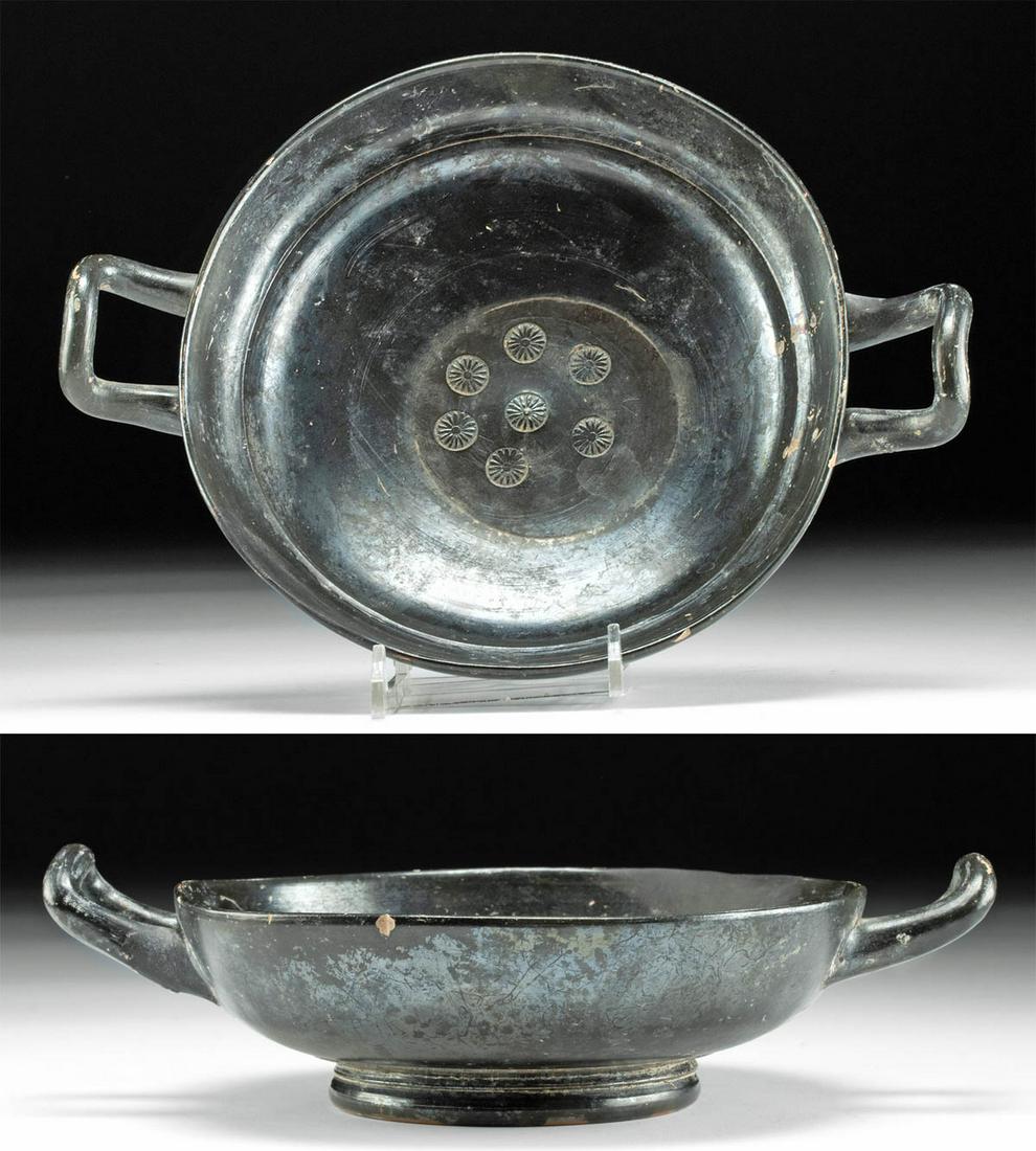 Greek Pottery Kylix with Stamped Floral Motifs: Greece, Athens, ca. 525 to 475 BCE. Truly a work of art! A gorgeous ceramic kylix with a perfectly round, deep bowl that stands on a circular foot, and twin, delicate handles projecting from the sides