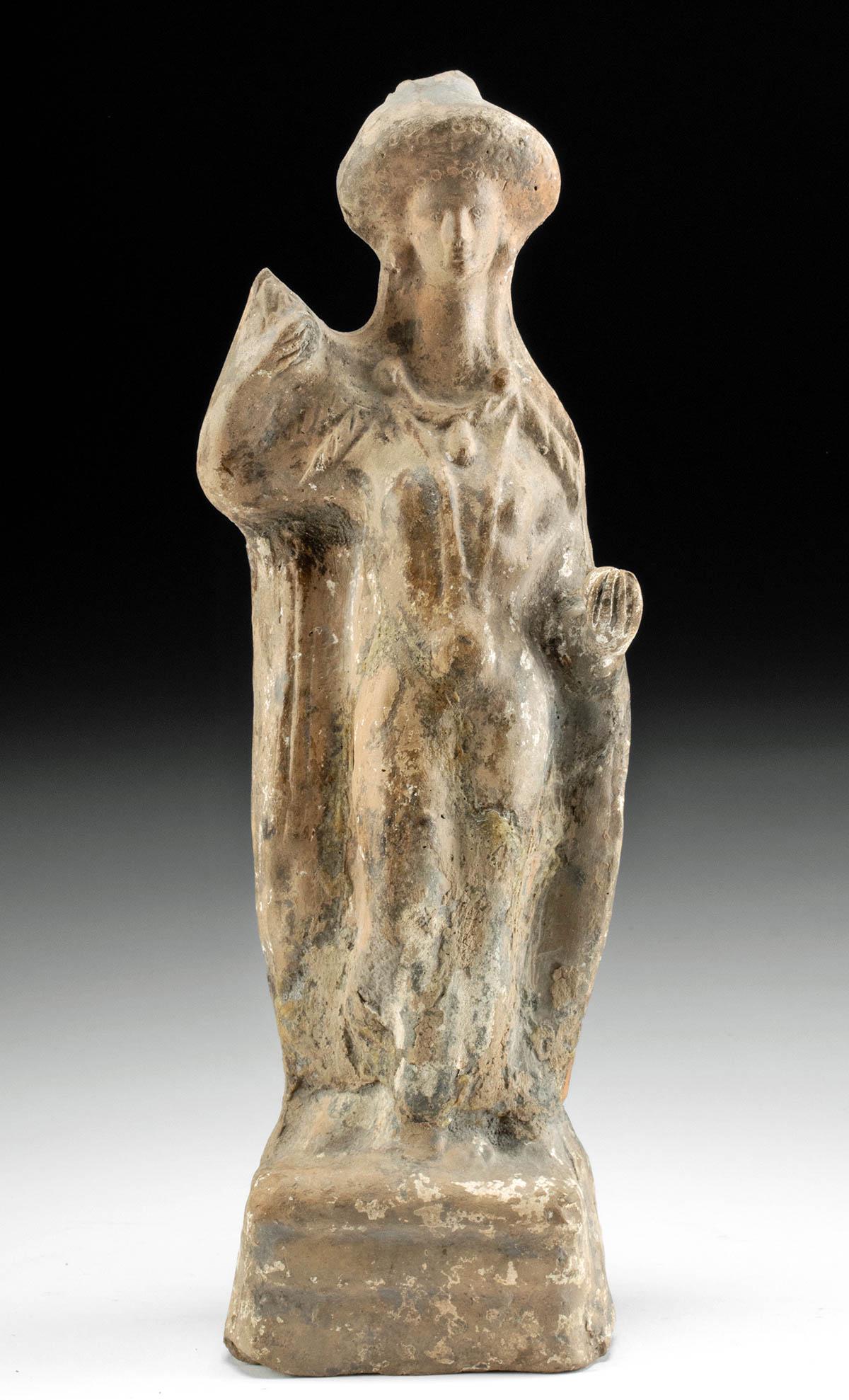 Greek Hellenistic Pottery Aphrodite Figure TL Tested: Greece, late Hellenistic period, ca. 2nd to 1st centuries BCE. An earthenware votive figure of the goddess Aphrodite, mold-made and hollow. She stands contrapposto on a cube pedestal, nude, with one h