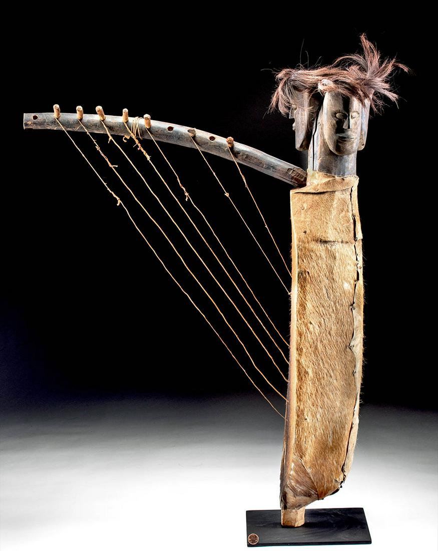 Early 20th C. Gabon Fang Wood, Hair, & Hide Ngombi Harp: West Africa, Gabon, Fang people, ca. early 20th century CE. A fascinating musical instrument known as a ngombi harp, made from wood, goat hide, fiber, and horsehair! The soundbox is formed from a holl