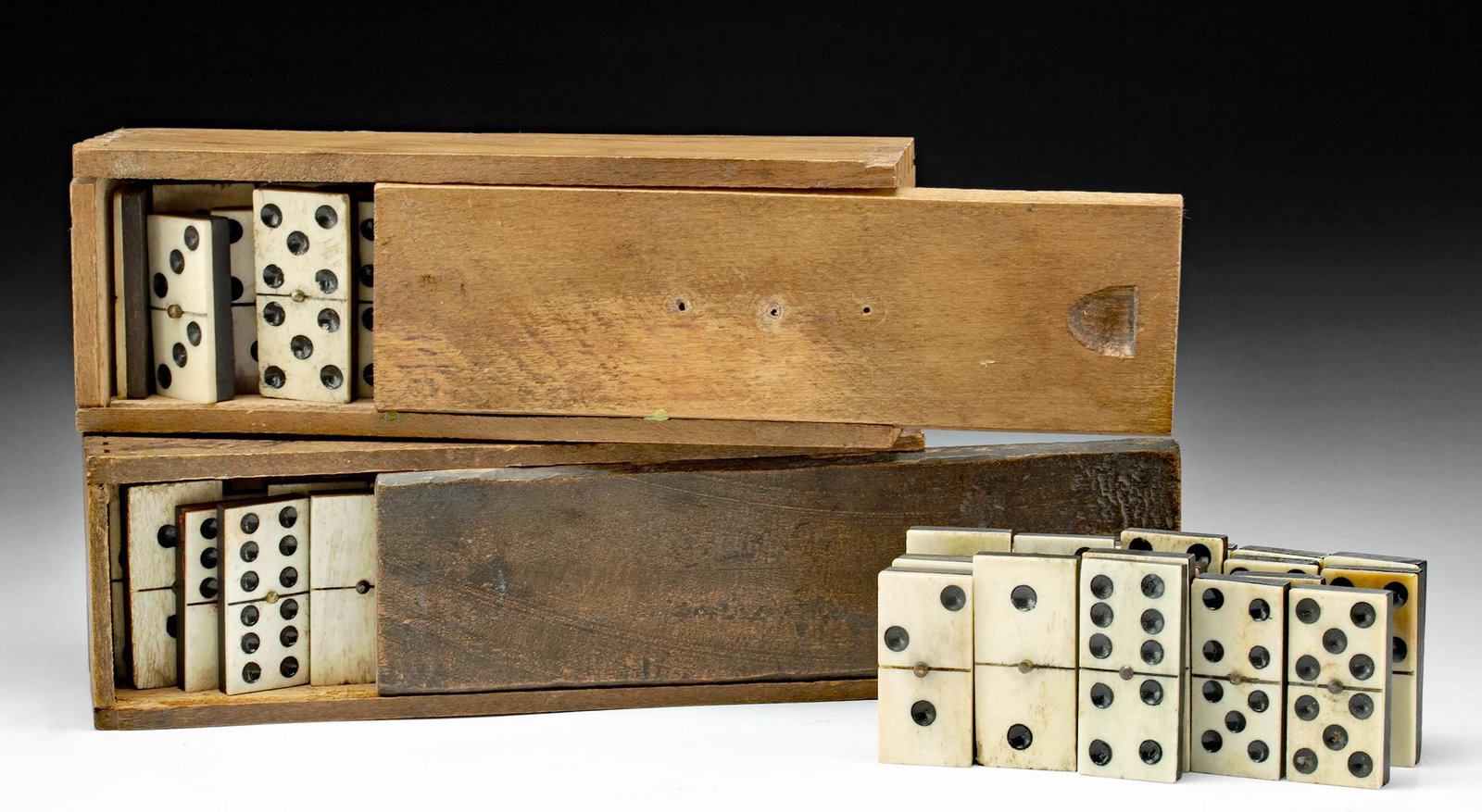 19th C. English Bone & Ebony Domino Sets w/ Cases: Northwestern Europe, England, ca. late 19th to early 20th century CE. A collection of carved antique ebony wood and bovine bone fronted dominoes in two wooden cases. The dominoes are handmade, and the