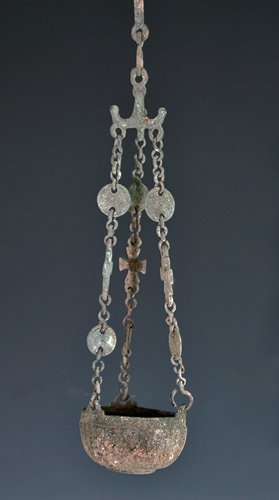 A Byzantine Bronze Censor: Ca. 500 to 800 A.D. The hemispherical bowl with ribbed decoration has three loops for attached chain /suspension; chain is composed of three crossed and two sets of coin-like pieces. 16"L x 3"W at cup