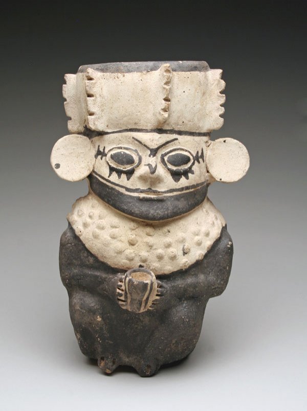 A Chancay Star Gazer: From Peru, ca. 1000 A.D. Typical standing stargazer Lord, with Royal ear ornaments, crown and pectoral, holding a ceremonial beaker. 10-1/2"H x 6"W. PROVENANCE: Ex-Butterfield's. (there is a reserve o