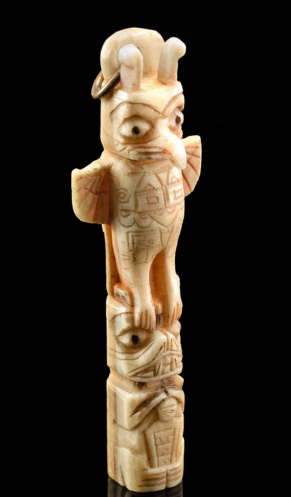 Early 20th C. Tlingit Walrus Ivory Totem Pole Pendant: Native American, Pacific Northwest, Haida or Tlingit, ca. early to mid-20th century CE. A charming hand-carved walrus tusk ivory totem pendant of an eagle perched atop a bear, with an upturned snout a