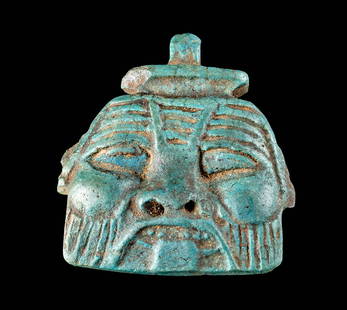 Fine Egyptian Late Dynastic Faience Bes Face Pendant: Egypt, Late Dynastic Period, 26th to 31st Dynasty, ca. 664 to 332 BCE. A highly detailed and mold formed faience pendant with the face of the dwarf god Bes. The visage is comprised of his