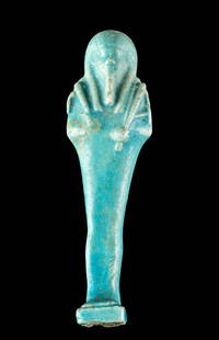 Egyptian Late Dynastic Glazed Faience Ushabti: Egypt, Late Dynastic Period, 26th to 31st Dynasty, ca. 664 to 332 BCE. A mold-formed faience ushabti of slender form standing in mummiform atop an integral plinth with a dorsal pillar on the verso.