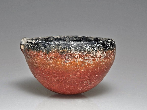 A Cypriot Knob-Lug Bowl: Early III-Middle Cypriot III, ca. 2000-1600 B.C. Medium-walled buff clay, polished red and black, fired black on inside and a band around the exterior rim, hemispherical in shape with a small string-h