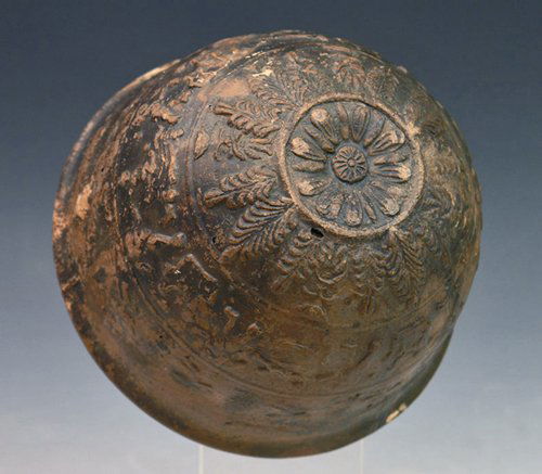 A Megarian-Ware Erotic Pottery Bowl, Hellenistic: Greece, ca. 2nd century BC. Of fine red clay, mold-made and black-glazed, the base centered by a rosette, a frieze above depicting a repeated lovemaking scene with a man standing on the left his hand