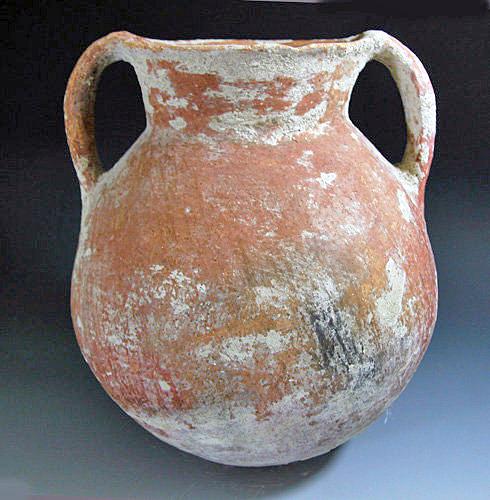 A Holy Land Redware Storage Jar: Dating to the Early to Middle Bronze Age - ca 2400 to 2000 BC. With polished exterior covered in red pigment flared rim and flattened base. 10-1/2"H. Provenance: ex-private northern Colorado collectio
