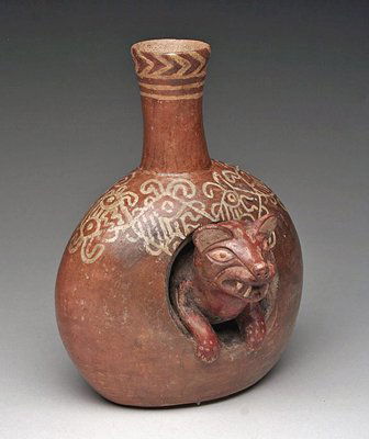 A Moche Huari Transition Vessel: Mochica / Huari / Wari Transition, Valley of Chao, from the North Coast of Peru, ca. 700 - 800 AD. Redware donut-shaped pottery vessel features a jaguar emerging from center. Note the delicate scrolli