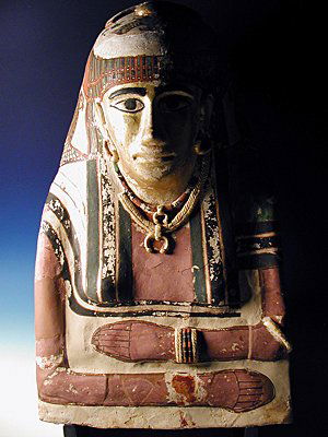 An Egyptian Female Mummy Mask: Ca. 1st century BC - 1st century AD. Gesso over plaster, with gilded jewelry, including necklaces, earrings, and bracelets. Beautiful colors. 23"H. Provenance: Ex-private Swiss Collection. no reserve