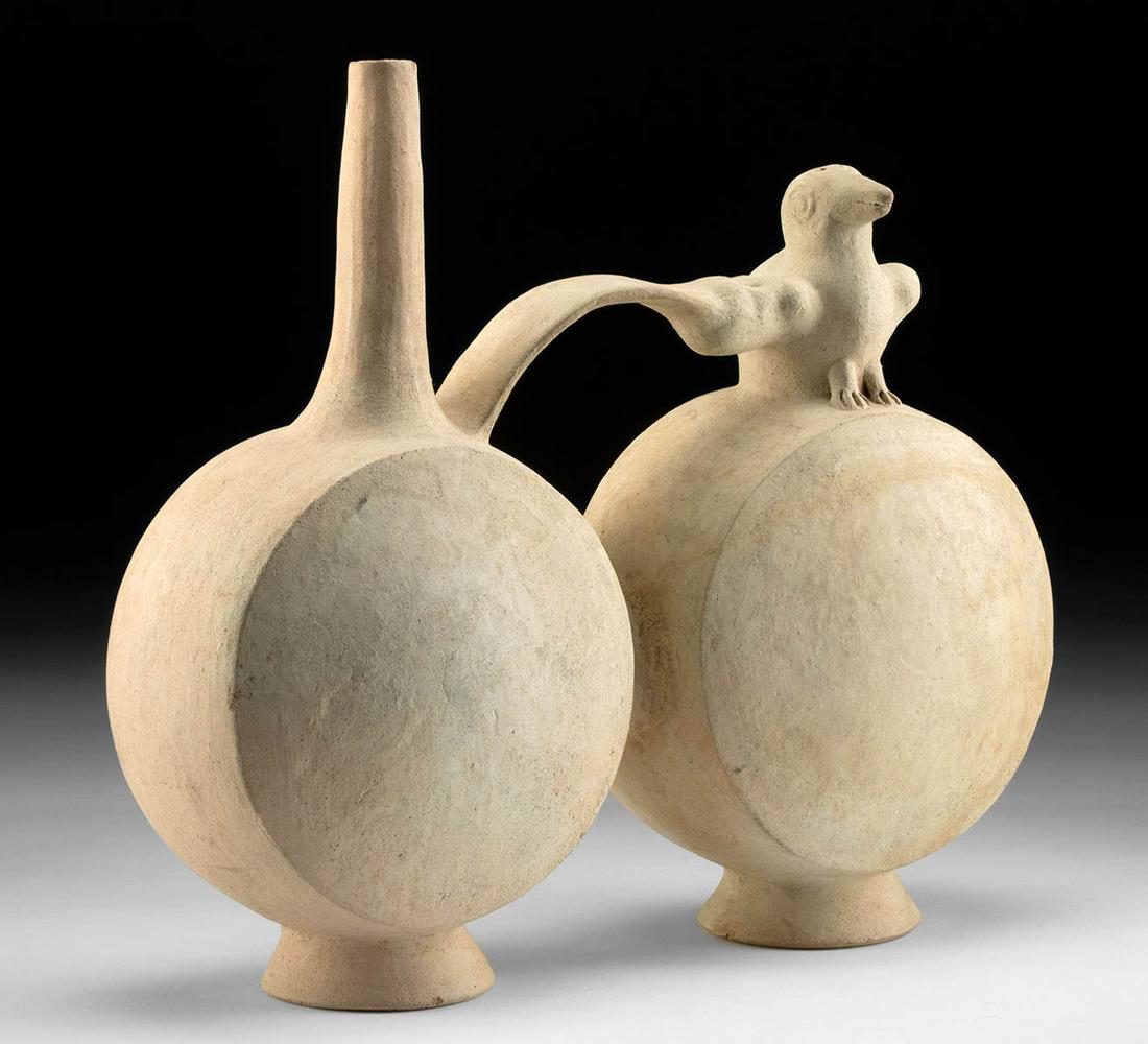 Chancay Pottery Whistling Stirrup Vessel w/ Bird: Pre-Columbian, North Coast Peru, Chancay, ca. 1000 to 1470 CE. An impressive whistling vessel enveloped in a creamy beige slip. Mold-made, the fascinating instrument features a pair of circular chambe