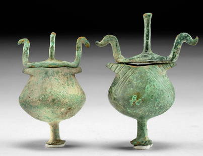 Greek Geometric Bronze Sickle-Type Pyxides (pr): Ancient Greece, Geometric period, ca. 8th century BCE. A wonderful pair of leaded bronze pyxides, each presenting a squat, globular body, a flared rim, a rounded bottom with a projecting tubular