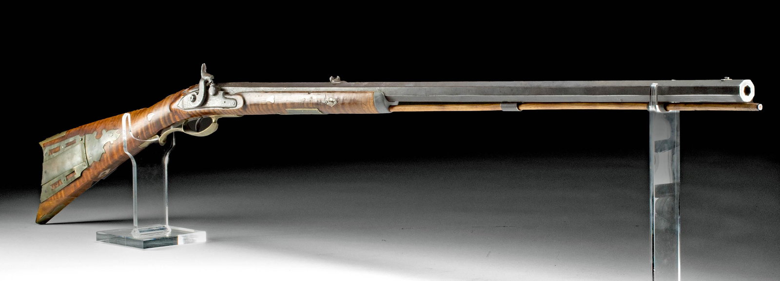19th C. USA Tiger Maple Long Barrel Percussion Rifle: North America, United States, ca. 19th century CE. A handsome percussion rifle with a lengthy iron barrel, wood stock, and brass fittings and inlays. The rifle has an octagonal steel barrel with a not