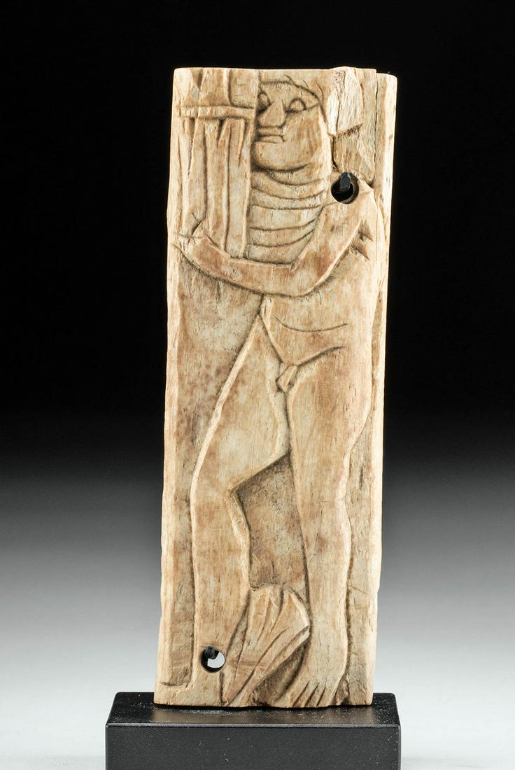 Published Roman Bone Panel Relief of a Youth: Roman, Alexandria, Imperial Period, ca. 4th to 5th century CE. A remarkable inlay of rectangular form depicting a youth, skillfully hand-carved from the bone of a deer or stag. Nude save for a cloak t